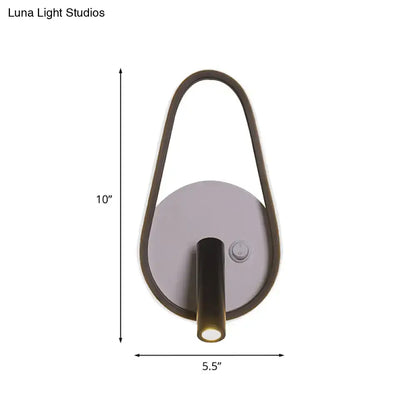 Modern wall light with sleek curved dark bronze frame and circular silver base emitting white warm light for bedroom use