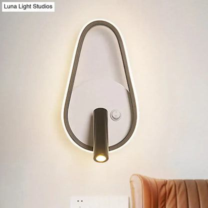 Modern black and white wall light with teardrop frame and integrated led emitting white warm light for bedroom use