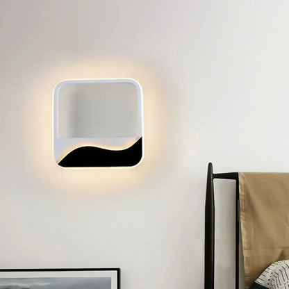 Modern black and white wave led flush mount wall lamp with sleek frame emitting warm ambient light for bedroom use