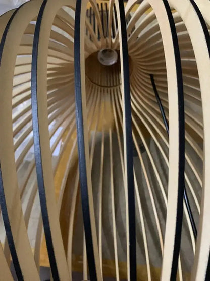 A modern pendant light with radial light-colored white wood cage and black accents for living room use