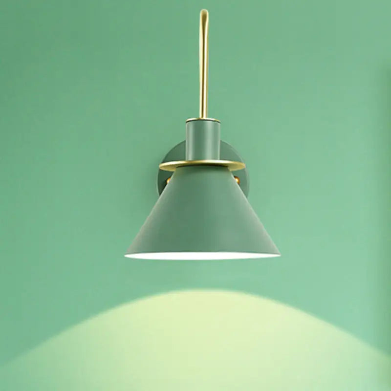 A sleek matte sage green conical wall sconce with brass arm and e26 e27 mounting for modern bedroom lighting