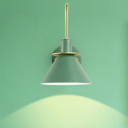 A sleek matte sage green conical wall sconce with brass arm and e26 e27 mounting for modern bedroom lighting