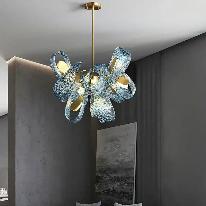 A modern chandelier featuring intricate swirling blue glass led shades and gold-toned metal accents pendant lamps decorbites blue glass