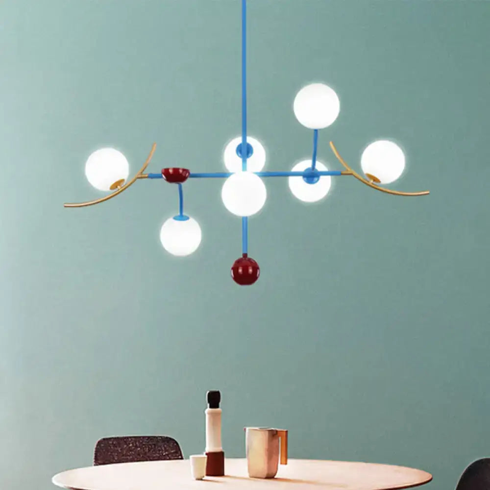 Modern blue and gold lamp fixture featuring opal glass ball shades and red accents for glass ball island dining room use