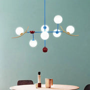 Modern blue and gold lamp fixture featuring opal glass ball shades and red accents for glass ball island dining room use