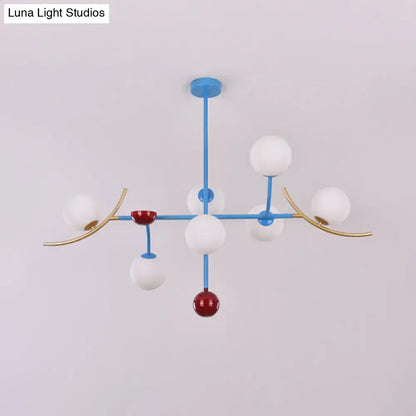 Modern blue and gold metal lamp fixture with white opal glass ball shades and red accent spheres for dining room island