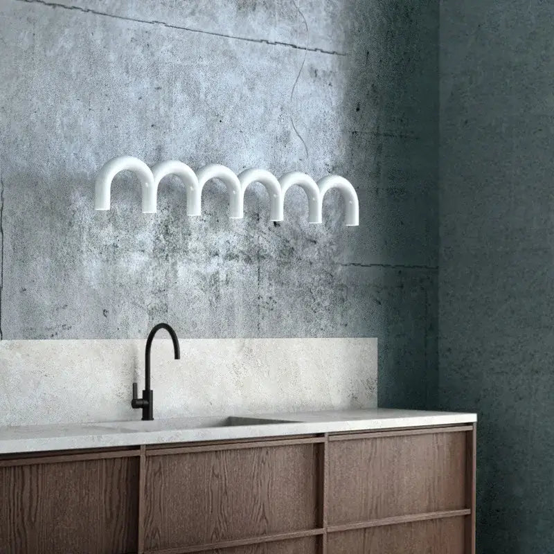 White minimalist u-shaped wall-mounted light fixture complementing decorbites blue metal arch chandelier design