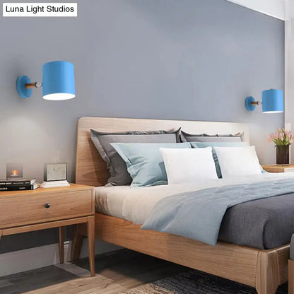 Modern blue metal tubular wall lamp with wooden arm sconce light showing a blue cylindrical inch fixture
