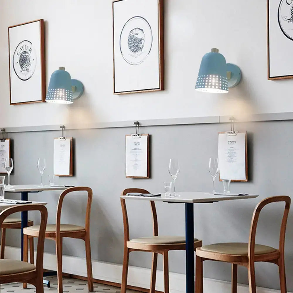 Modern blue metallic bell wall sconce with light blue bell shape and perforated lower section for restaurant lighting