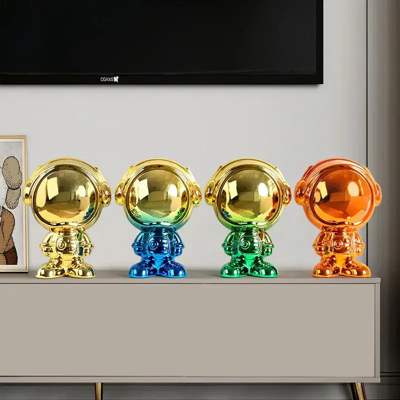 Four glossy metallic astronaut statue figurines in gold blue green and orange for modern living room decorbites decor