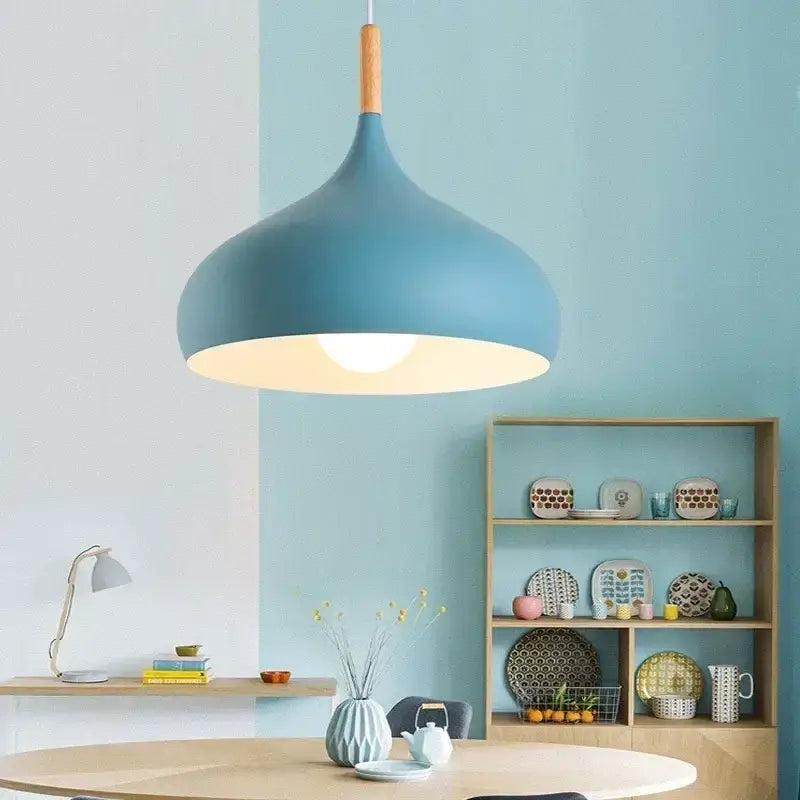 Modern blue pendant light with stainless steel construction, wooden stem, and warm diffused glow for bedroom use