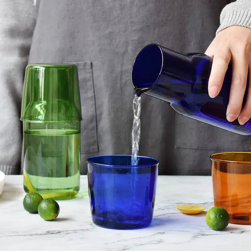 Deep blue modern borosilicate glass tea pot being poured into a matching glass for kitchen fruit infusion