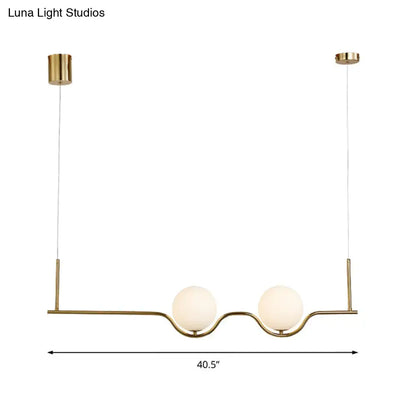 Gold-toned modern pendant ceiling light with two frosted white glass shades and adjustable cords for living room use