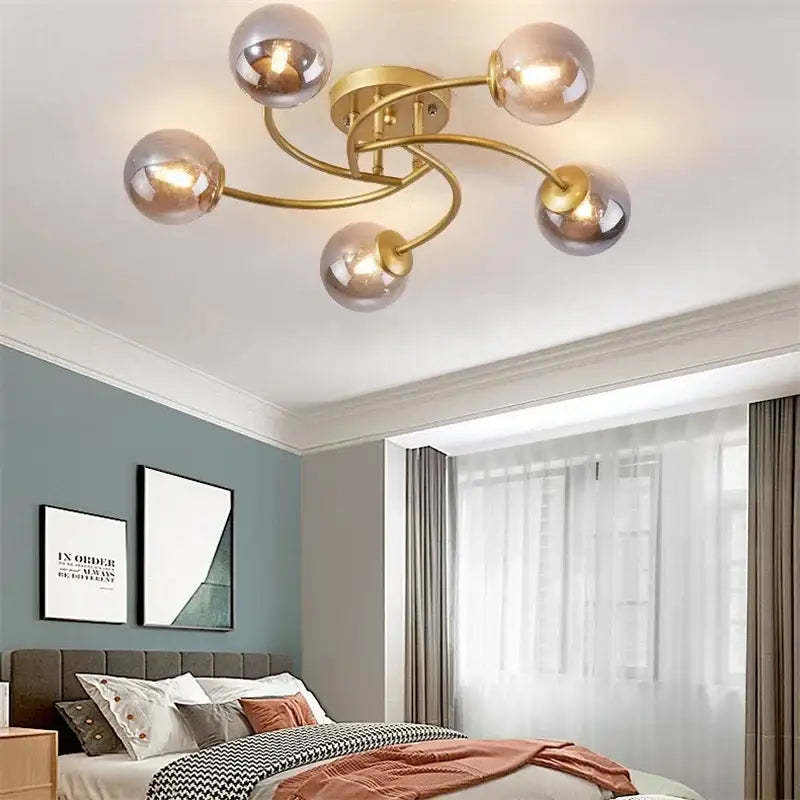 Modern brass ceiling light fixture with five frosted glass bulb globes for kitchen lighting