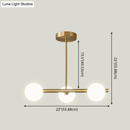 Modern brass pendant light with three spherical glass shade bulbs designed for dining room illumination