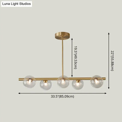 Modern brass pendant light with five spherical glass shade bulbs for dining room lighting