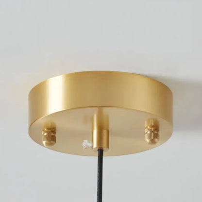 Modern brass and amber glass pendant light with gold circular ceiling fixture and copper bauhaus led mounting screws