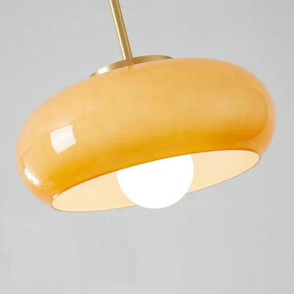 A sleek amber glass pendant light with a rounded dome and brass stem perfect for kitchen led lighting decorbites copper bauhaus