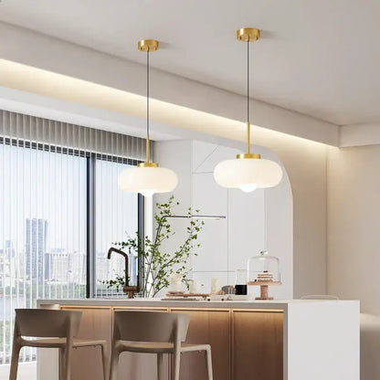 Two modern pendant lights with gold-finished metal fixtures and frosted glass shades for kitchen led lighting decorbites copper bauhaus