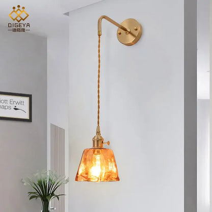 Modern brass wall lamp with decorbites amber glass shade and twisted cord for bedroom living room lighting