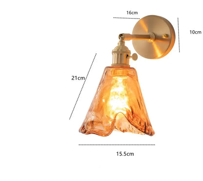 Modern brass and amber glass wall lamp with warm amber glass lampshade and brass-finished metal arm for bedroom decorbites amber glass