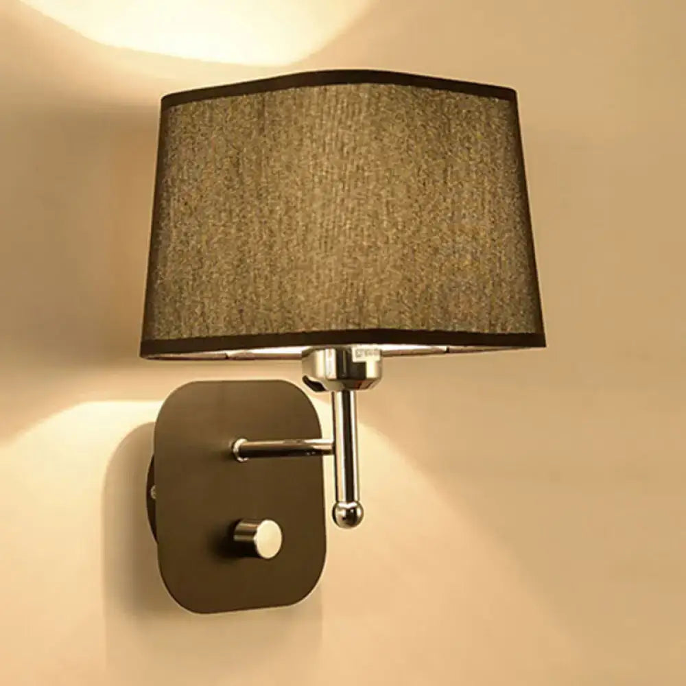 Modern wall sconce lighting with textured taupe fabric shade and sleek chrome metal arm for bedroom use