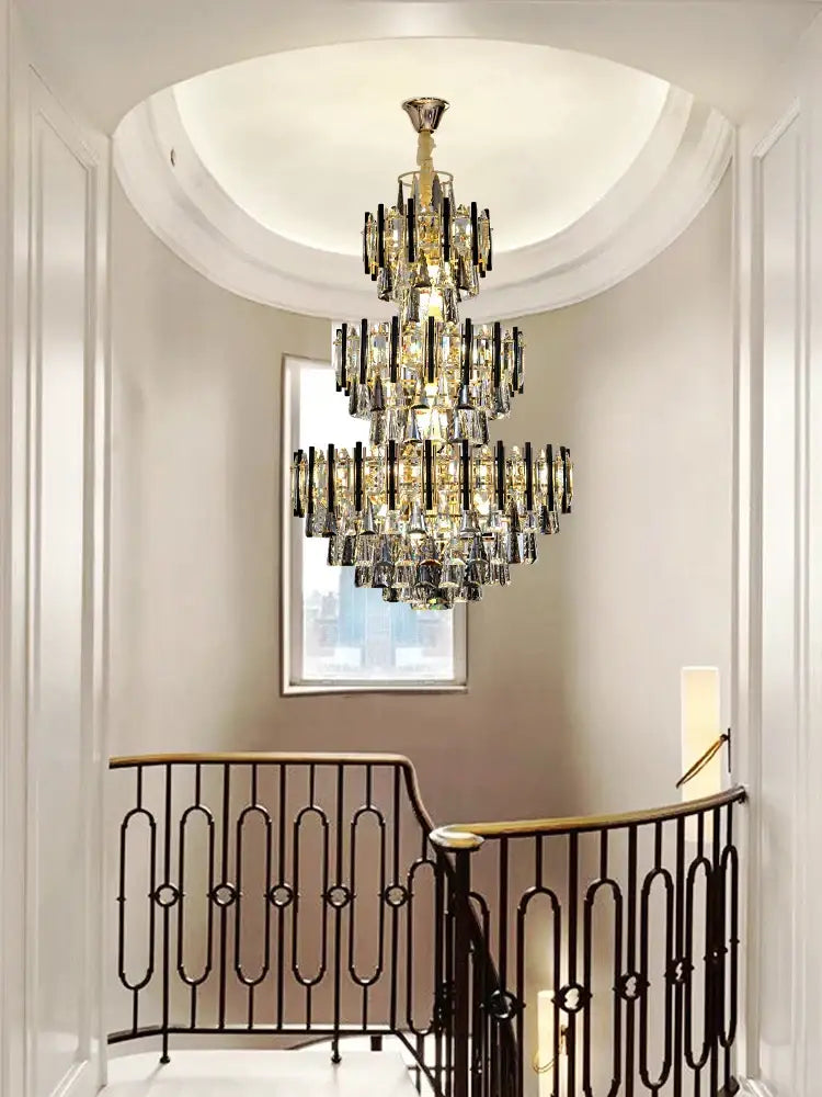 A modern brass and black crystal hollow villa chandelier with multi-tiered design hangs from a curved ceiling