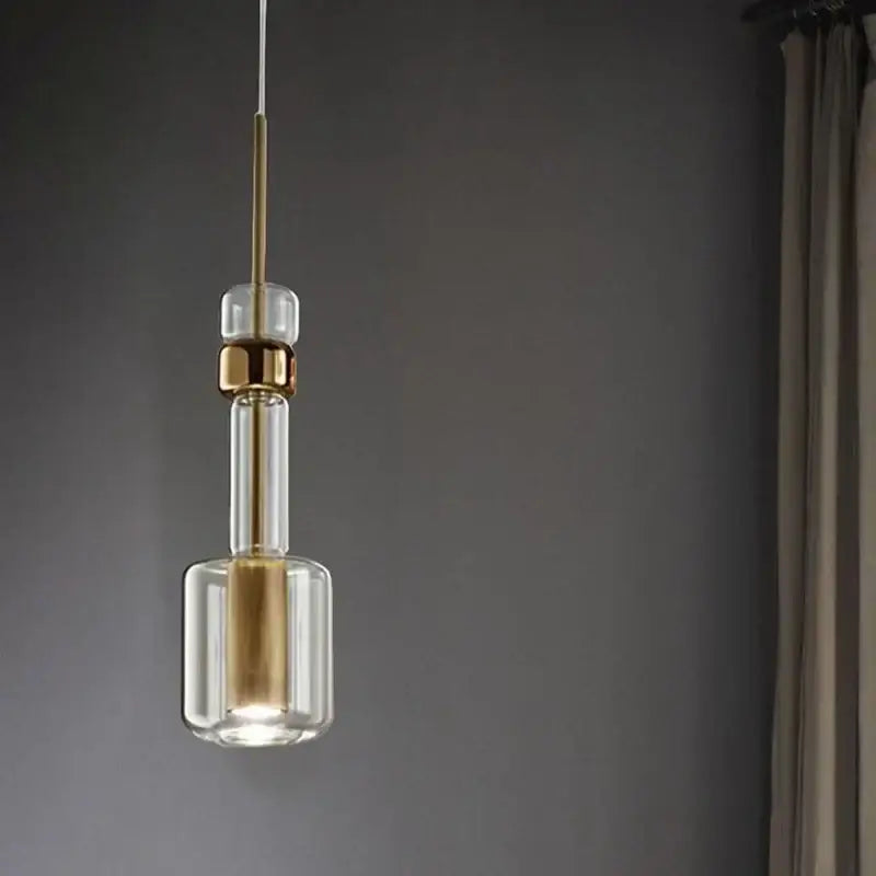 Modern brass and black cylindrical glass pendant light with clear glass and gold-toned metal accents for kitchens decorbites cylindrical glass pendant