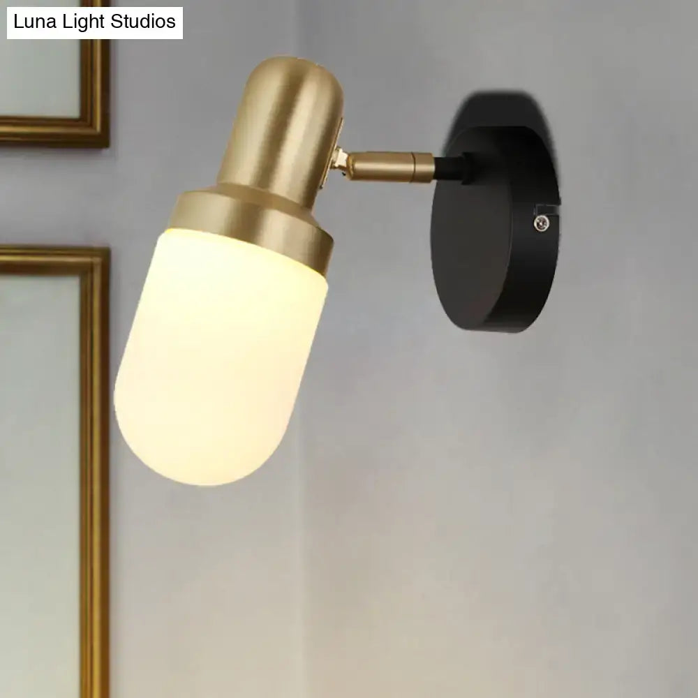 Modern brass and black glass sconce light with frosted glass shade and black mounting plate for bedroom wall lighting