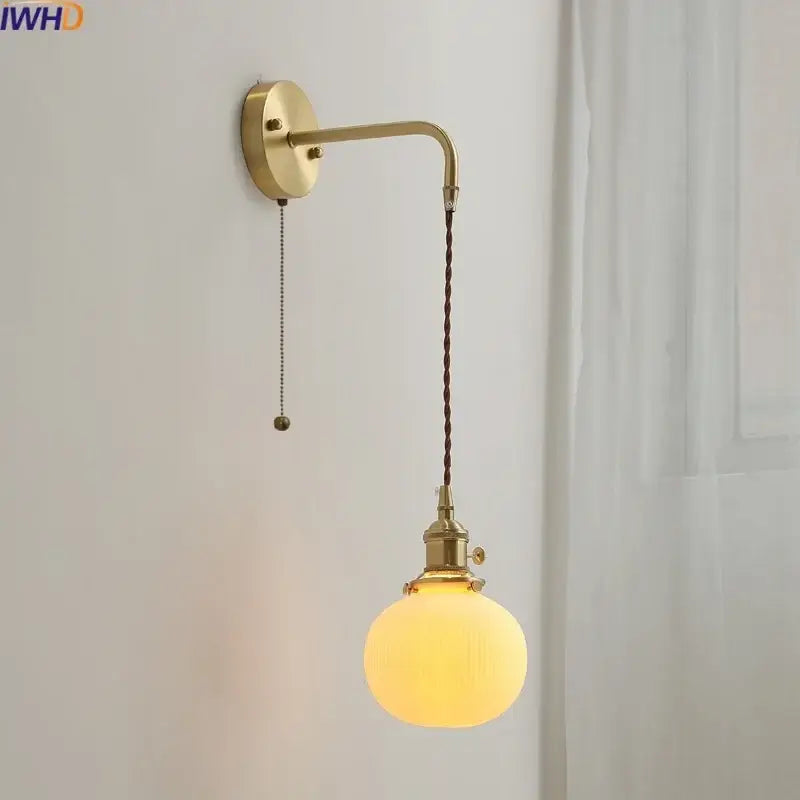 Modern brass and ceramic copper led wall lamp featuring a brass finish, twisted brown cord, and frosted glass globe bulb