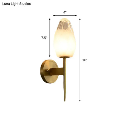Modern brass and clear glass wall lamp bedroom sconce with a warm frosted glass shade and brass-finished metal base and stem