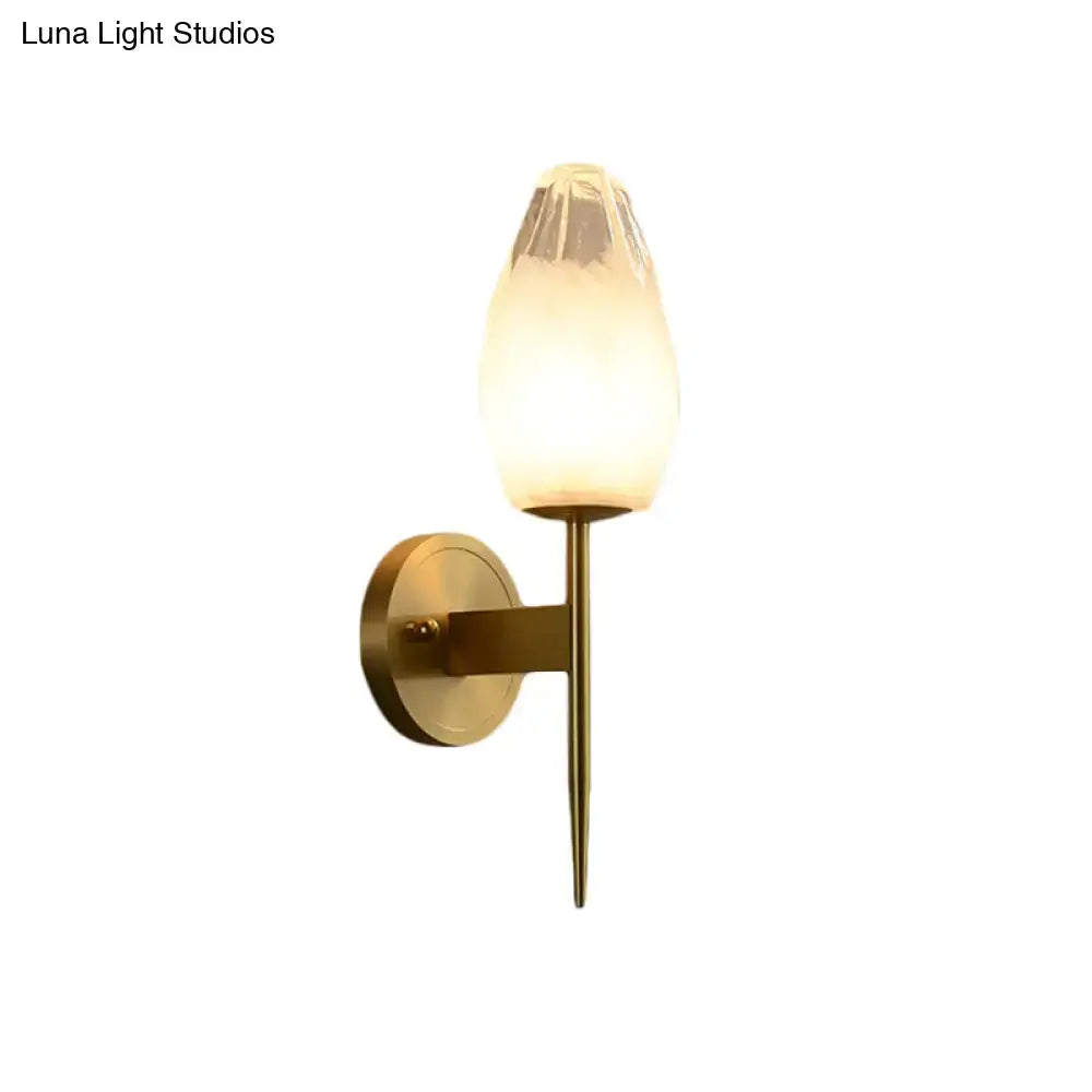 Modern brass and clear glass wall lamp with frosted glass shade and brass base ideal for bedroom sconce lighting