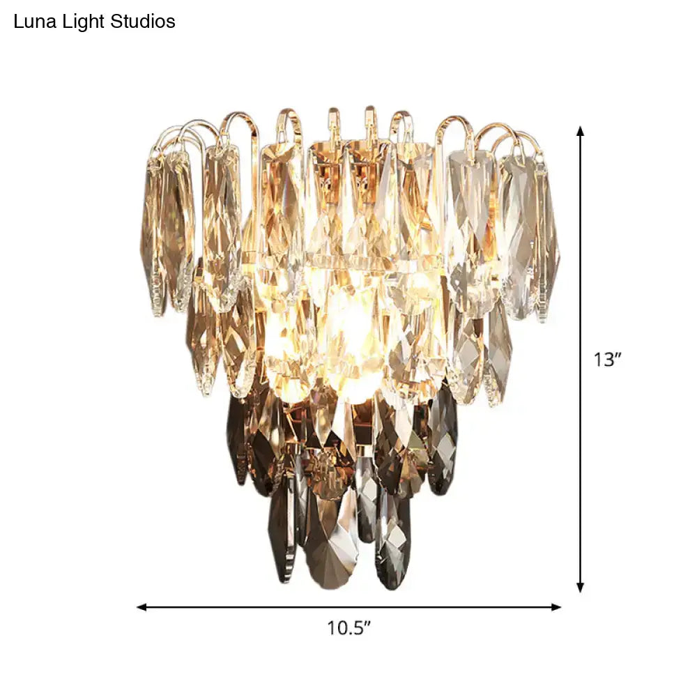 Modern brass and crystal tiered wall sconce with gold-toned metal and clear, amber, and dark faceted crystals