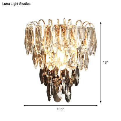 Modern brass and crystal tiered wall sconce with gold-toned metal and clear, amber, and dark faceted crystals