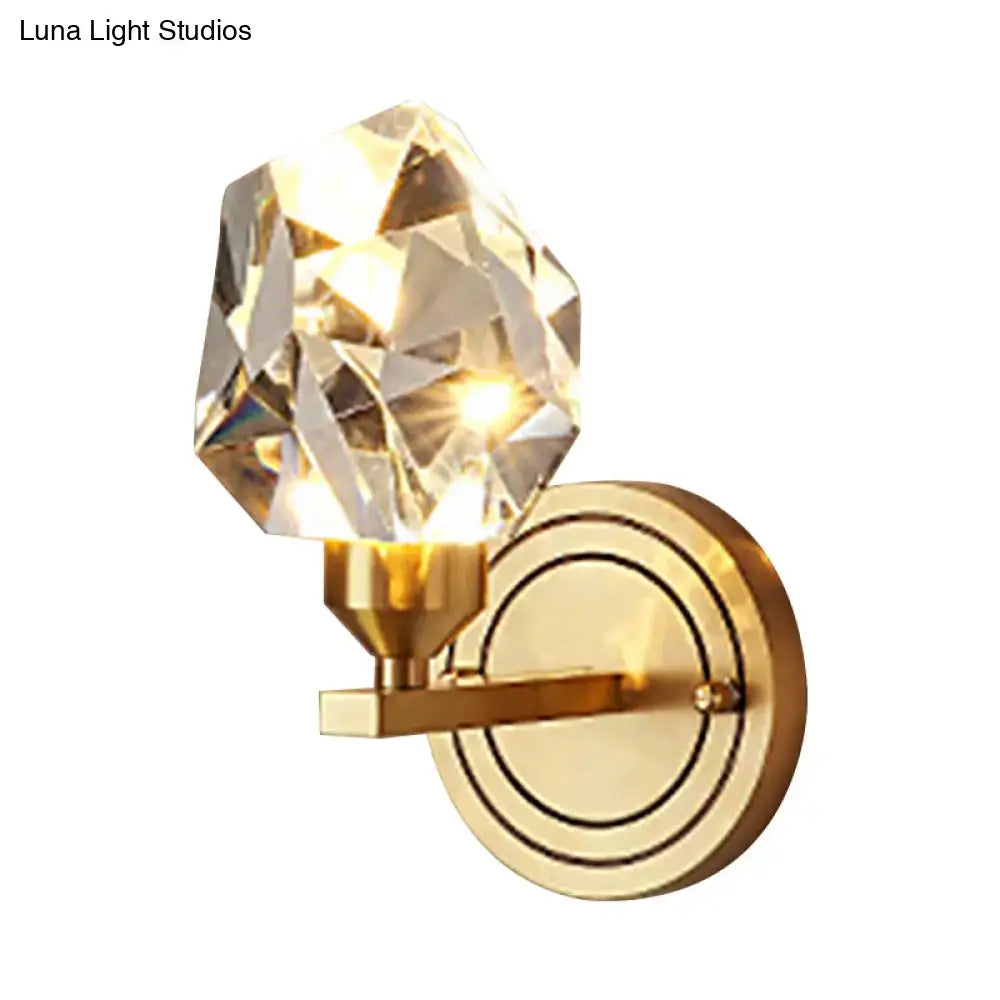 Modern brass and crystal wall mount light with faceted crystal globe refracting warm light for living room decor