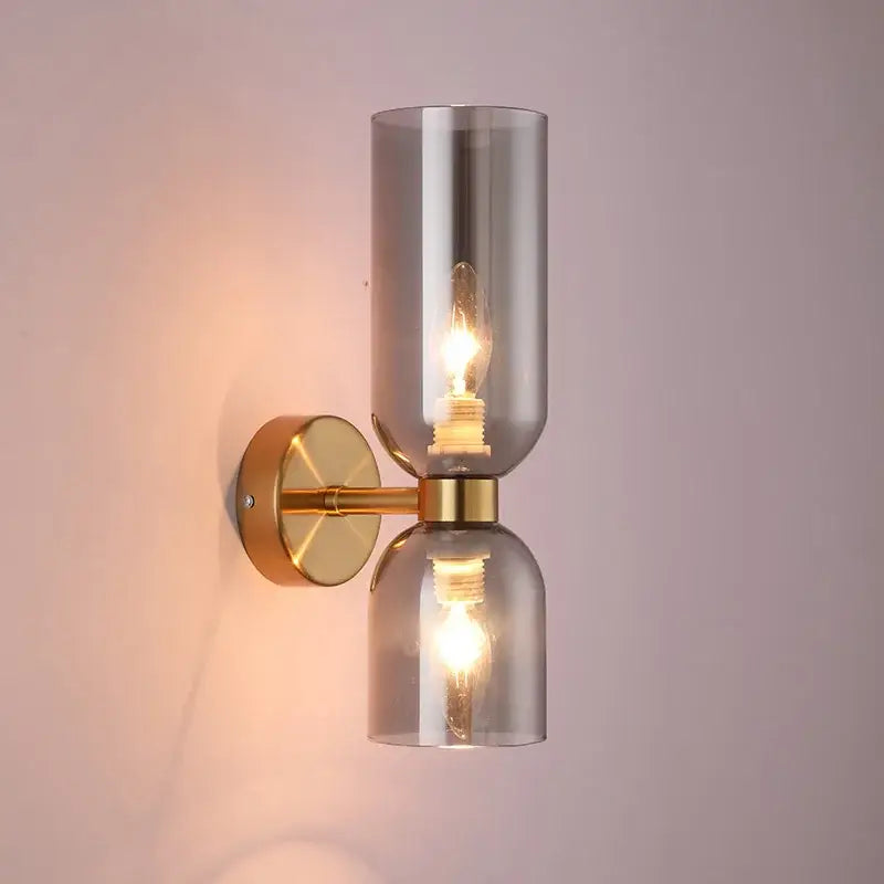 Modern wall lamps featuring two smoked decorbites glass ball shades with brass accents for bedroom sconces