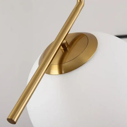 Modern brass pendant light with gold-toned metal arm and frosted white glass ball for dining room decorbites glass ball fixture