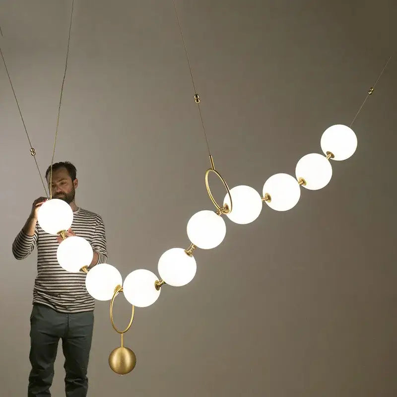 Modern brass and glass ball pendant light with frosted white glass balls and polished brass rings for dining room decorbites glass ball pendant