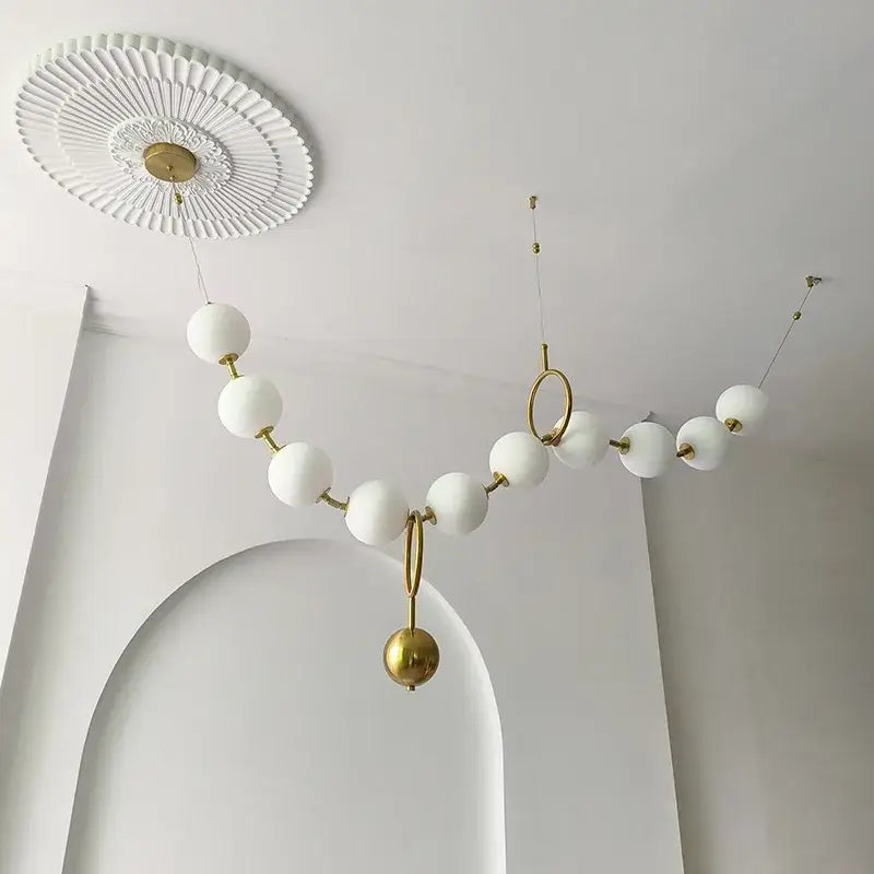 Modern brass and glass ball pendant light with white glass orbs and gold-toned metal for dining room decorbites glass ball chandelier