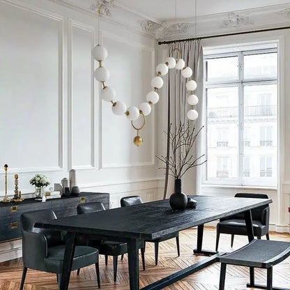 Modern black wooden dining table with matte finish shown beneath decorbites glass ball pendant dining room chandelier