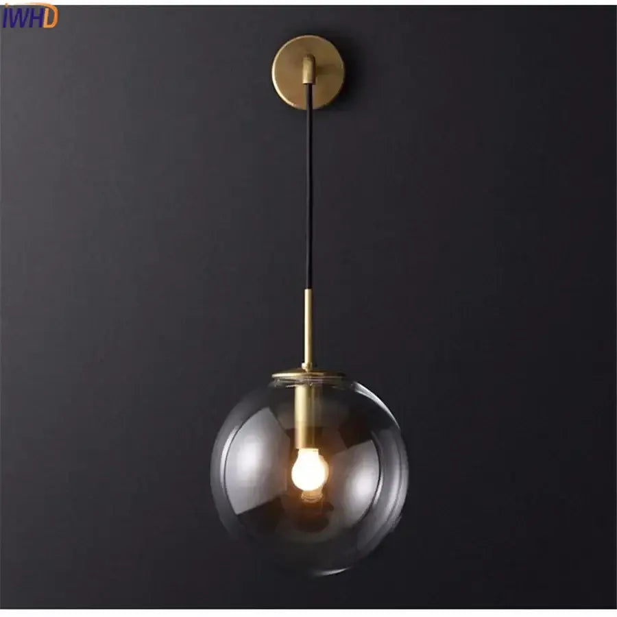 Modern brass and glass ball wall lamp with a spherical glass ball and sleek black cord for bathroom sconce decorbites glass ball
