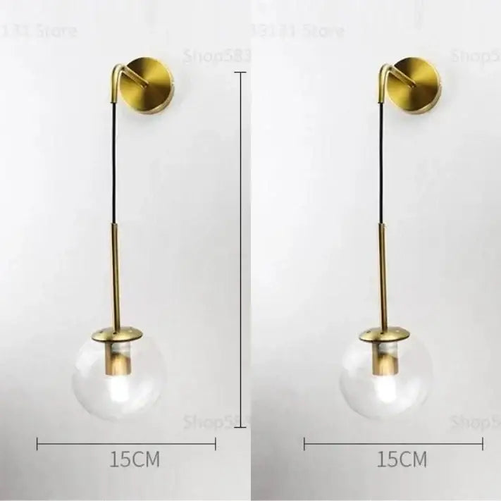 Modern brass and glass ball wall lamp with gold-toned wall sconce and clear glass globe for bedroom decorbites glass ball