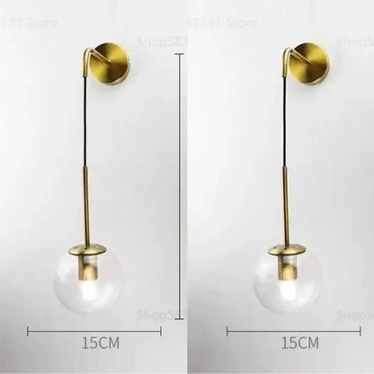 Modern brass and glass ball wall lamp with gold-toned wall sconce and clear glass globe for bedroom decorbites glass ball