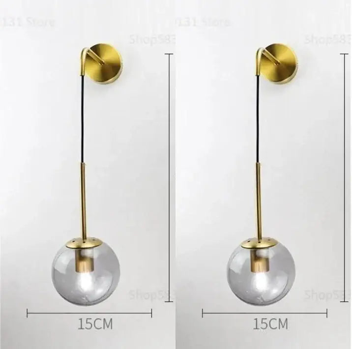 Modern brass and glass ball wall lamp with gold-toned spherical pendant and clear glass globe for bedroom decorbites decor