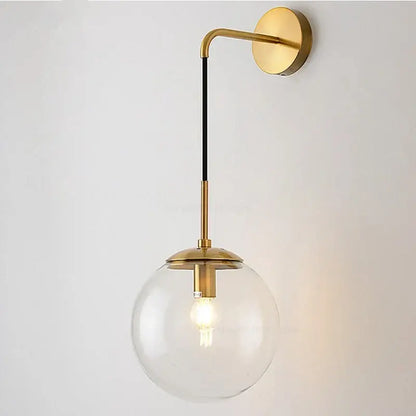 A modern brass wall lamp with a clear glass ball and black accent rod for bedroom decorbites glass ball lighting