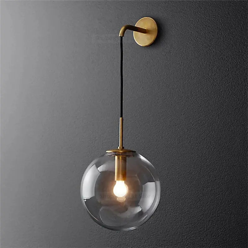 Modern brass and glass ball wall lamp with brass finish and clear glass globe for bedroom decorbites glass ball lighting