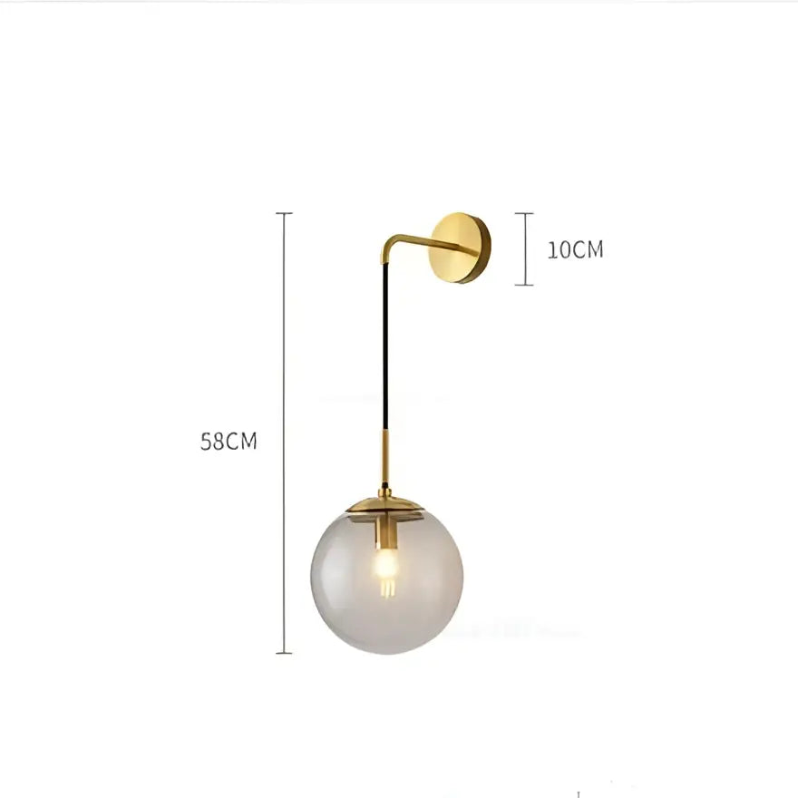 Modern brass and glass ball wall lamp with gold metal arm and smoked glass globe for bedroom decorbites glass ball decor