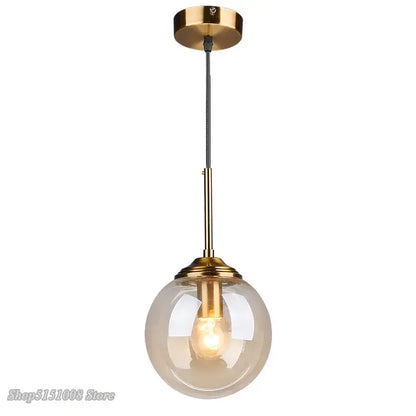 Modern brass and glass pendant lights featuring a spherical translucent glass pendant for kitchen and dining room