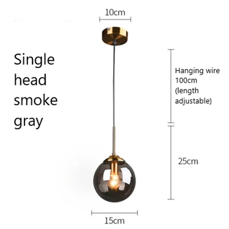 A sleek modern brass pendant light with a smoke gray glass pendant globe ideal for kitchen or dining room