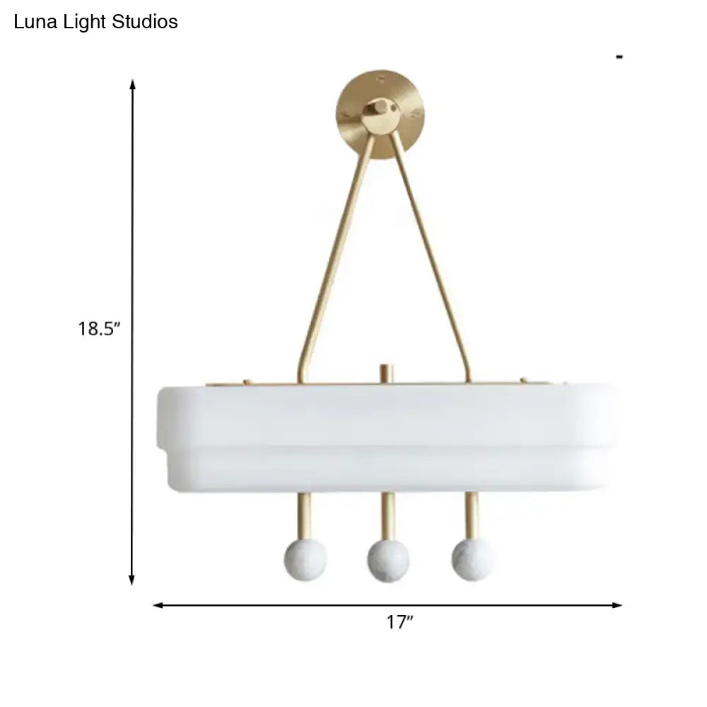 Modern white rectangular pendant light with gold-toned metal arms and spherical accents as a sconce light fixture